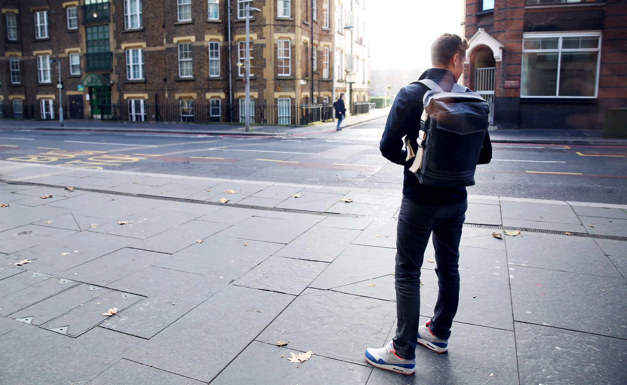 Man with backpack standing in a street
